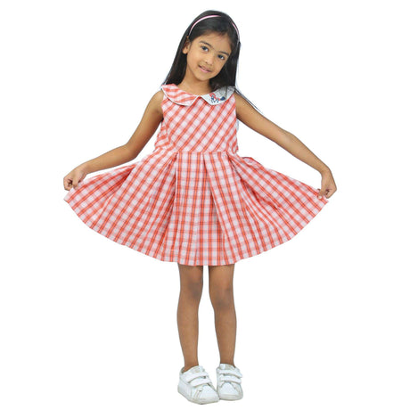 A little girl in red plaid dress with two tone hand embroidered collar and back tabs