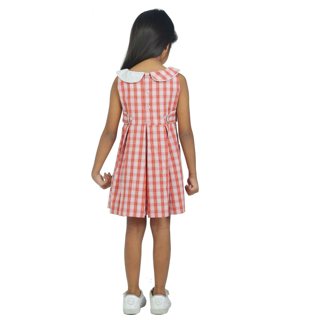 Girl wearing a box pleat skirt sleeveless dress in red plaid
