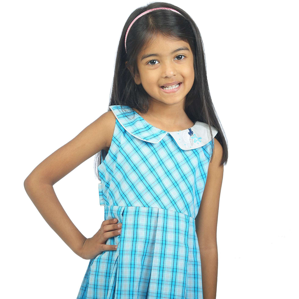 Close-up of a little girl in blue plaid sleeveless dress with a hand embroidered collar and box pleats