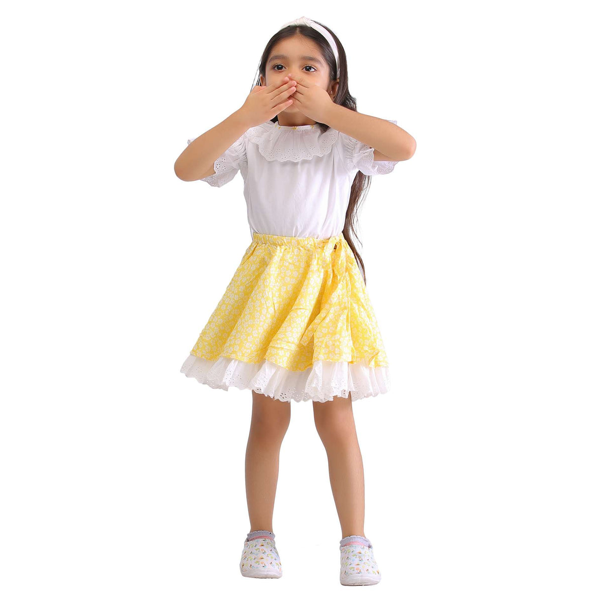 Girl wearing yellow floral skirt and white blouse with lace trims
