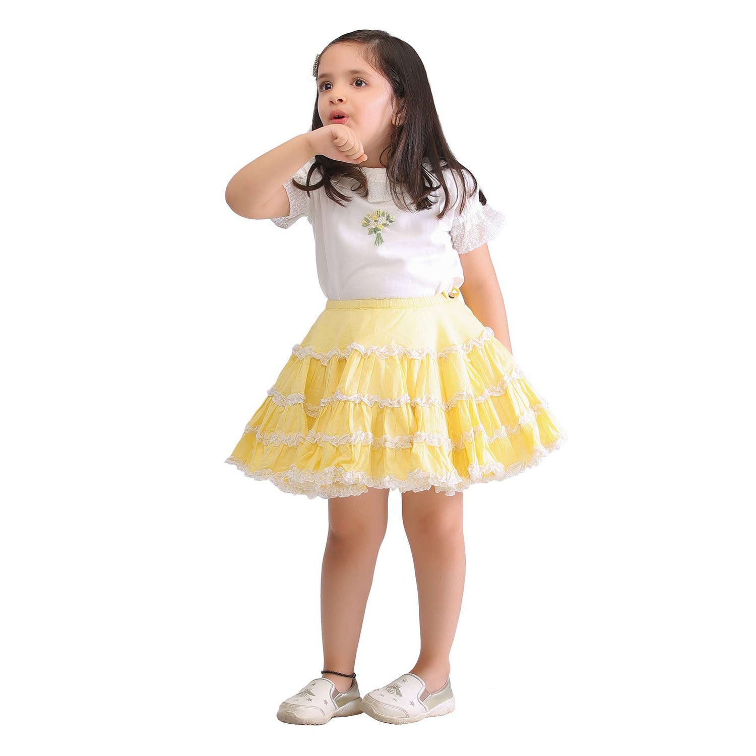 Girl wearing a heavily gathered yellow slitrt and ivory embroidered blouse