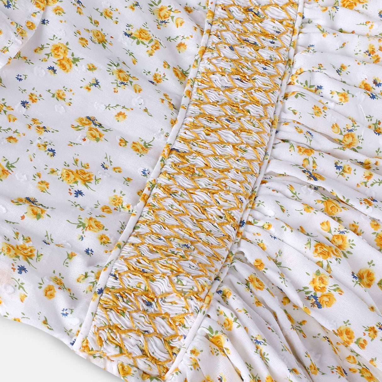 Close-up of swiss-dot floral dress with ruffled collar, hand-smocked waistline and lace trims on sleeves and hem