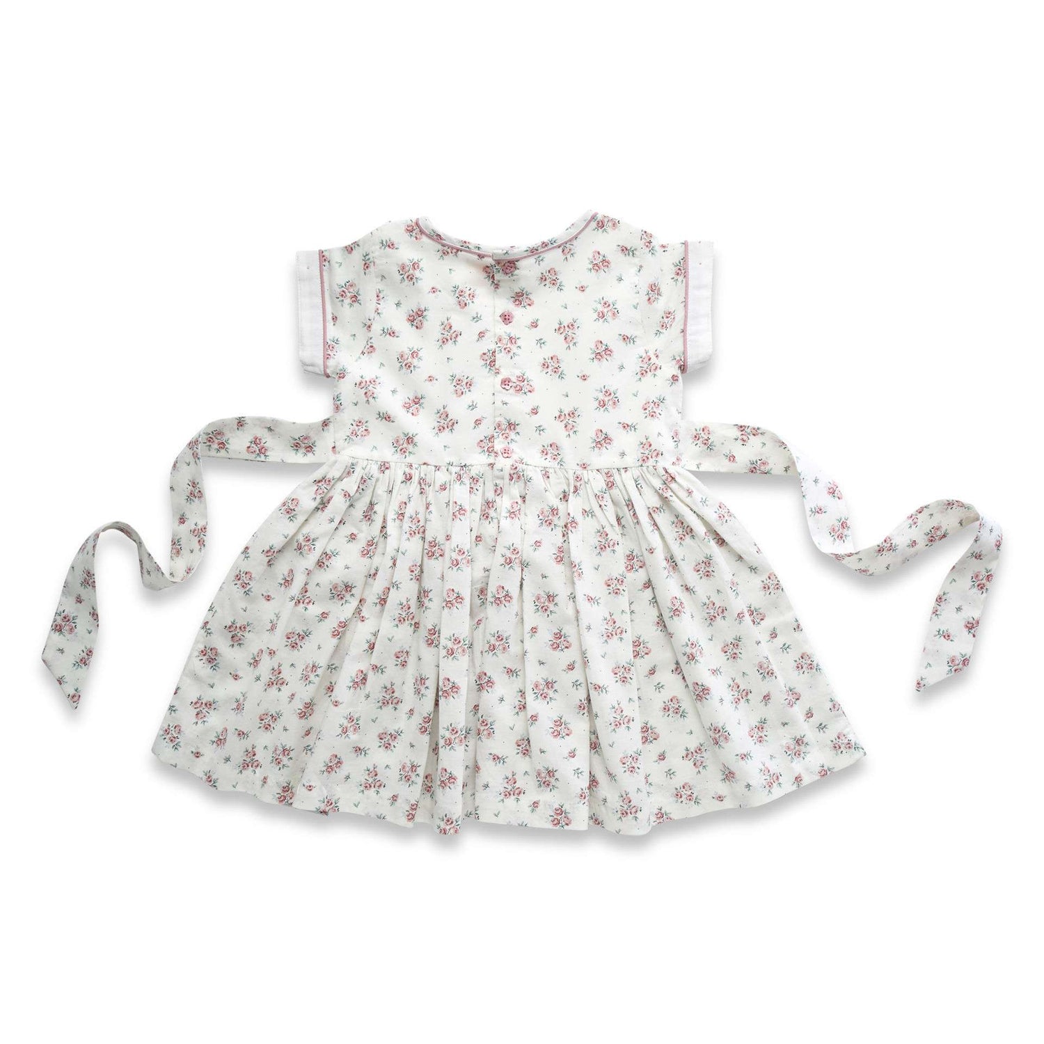 Flatlay of the rear side of ivory floral printed dress with hand embroidered details and a tie-up sash in the back
