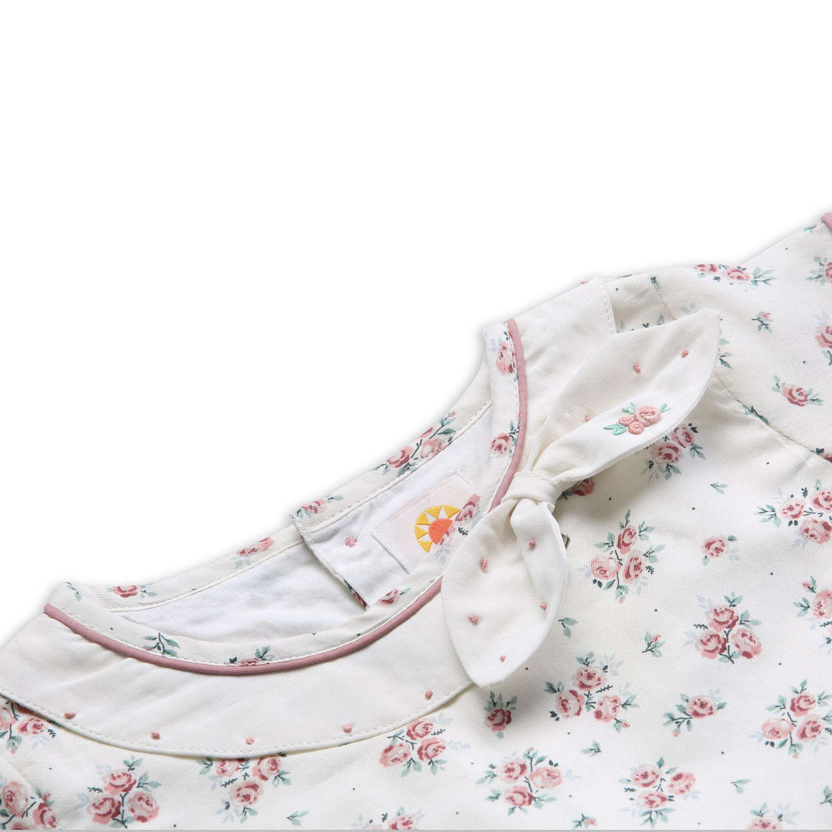 Close-up of hand embroidered details on the collar of ivory floral printed dress