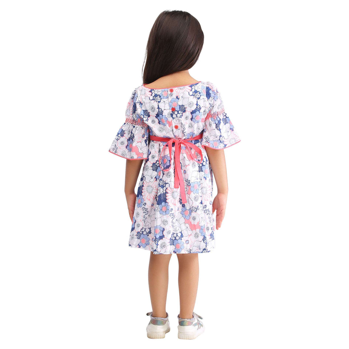 A little girl in swiss dot pink and blue floral printed cotton dress with bell sleeves