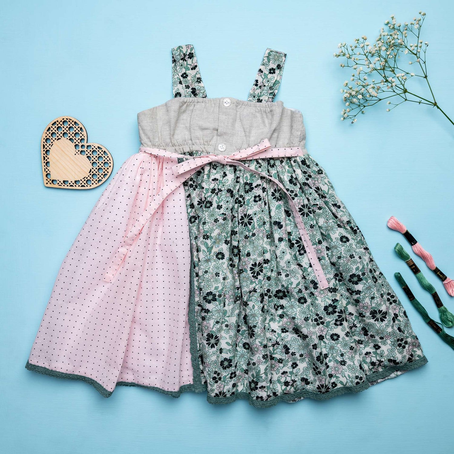 Rear view of strappy dress with floral print and pink dot fabric with intricate ribbon patchwork heart applique