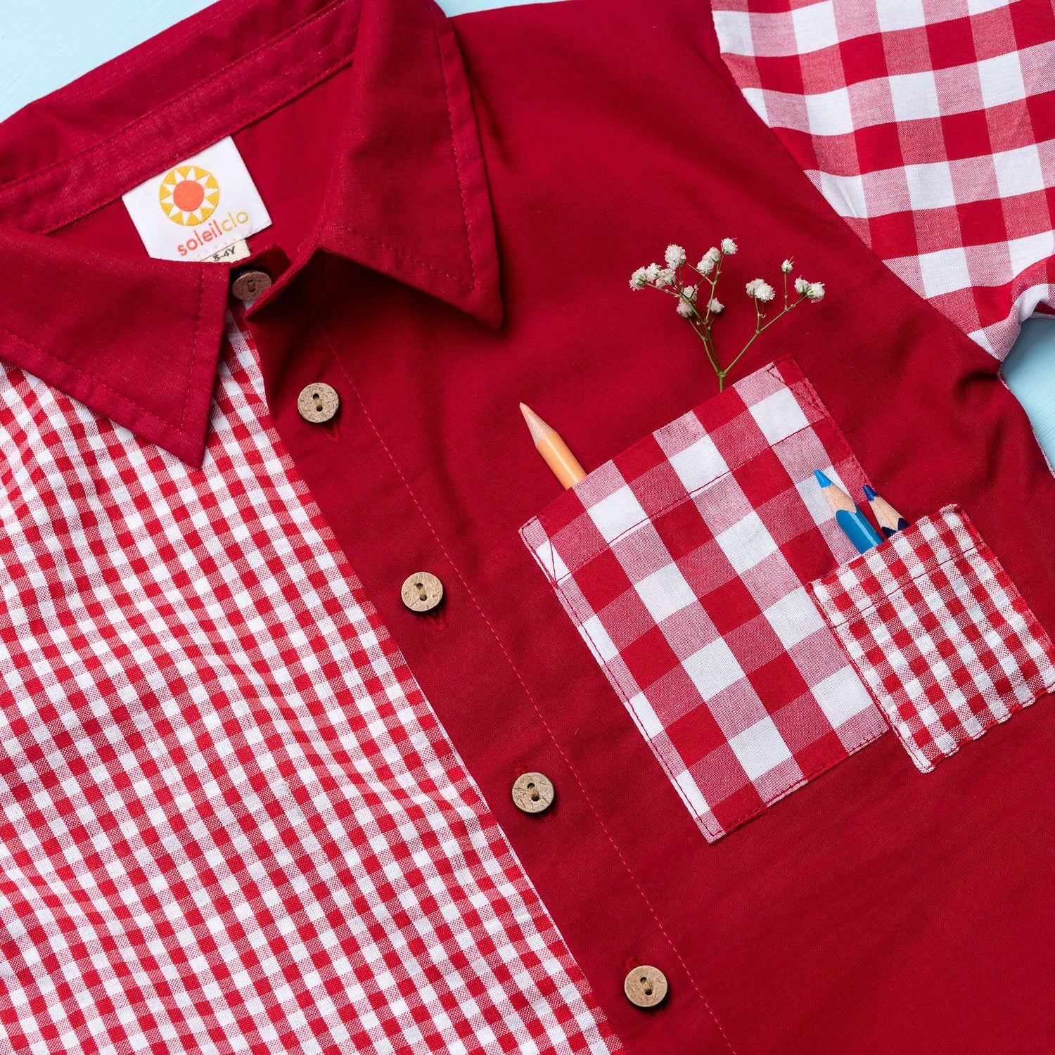 Flatlay of red checked shirt made from a patchwork of big and micro red gingham and solid red voile