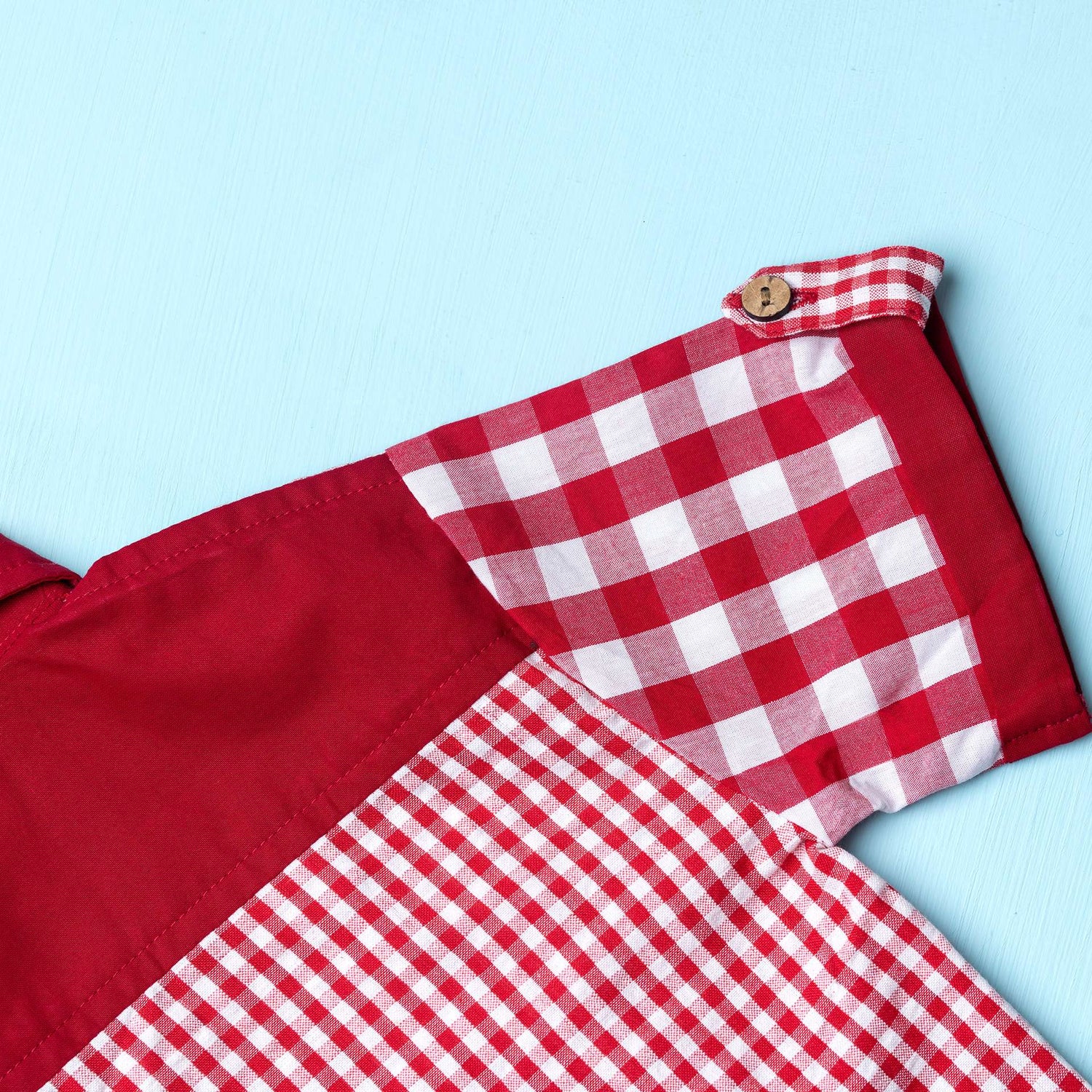 Close-up of red checks shirt made from a patchwork of big and micro red gingham and solid red voile