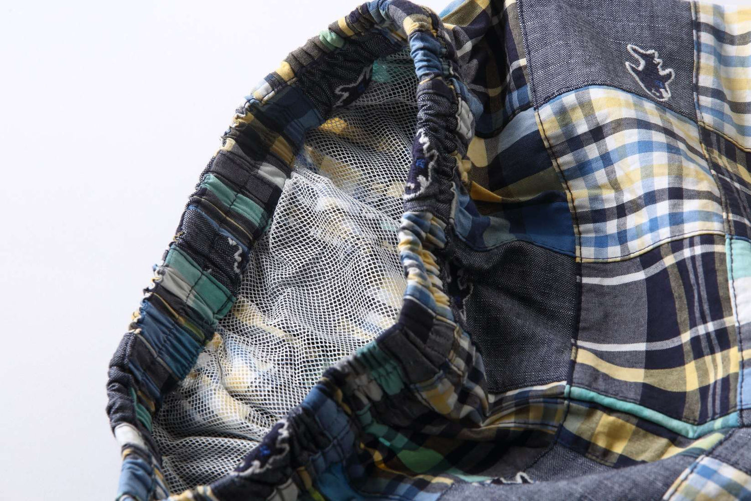 Close-up of the waist elastication and inner mesh lining in blue fish embroidered patchwork boy’s swimming trunk