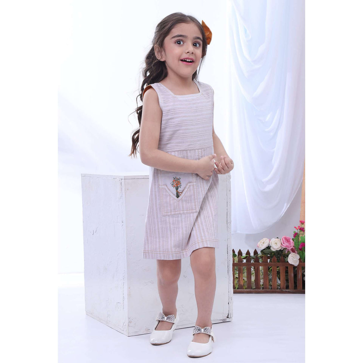 Girl runs in a sleevelss A-line ivory dress with pocket embroidery