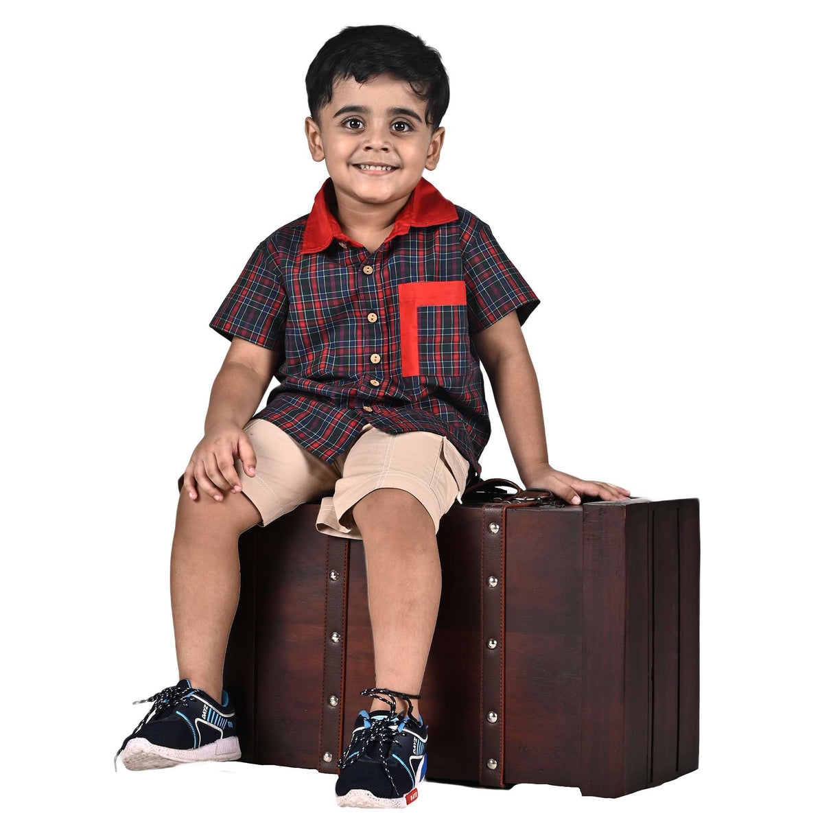 A little boy in red and green checked shirt with red collar and double pocket paired with tan cargo shorts