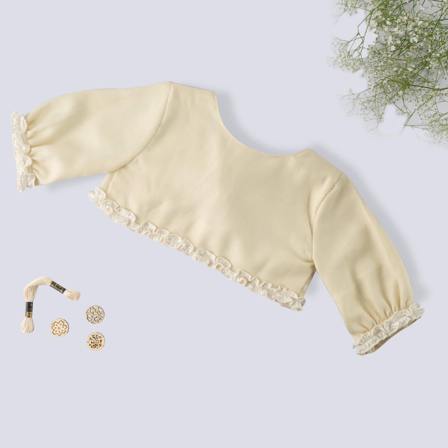 Flat lay view of an ivory bolero embroidered girls jacket with lace details