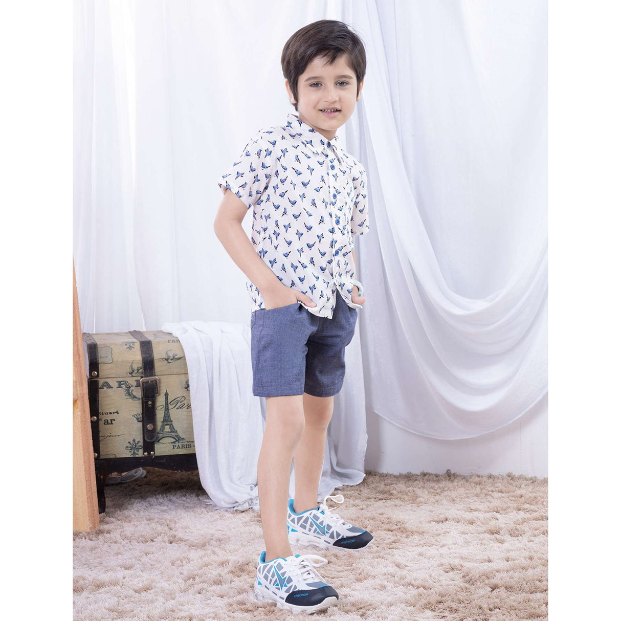 A boy posing in soft cotton bird printed collared shirt with contrast blue buttons