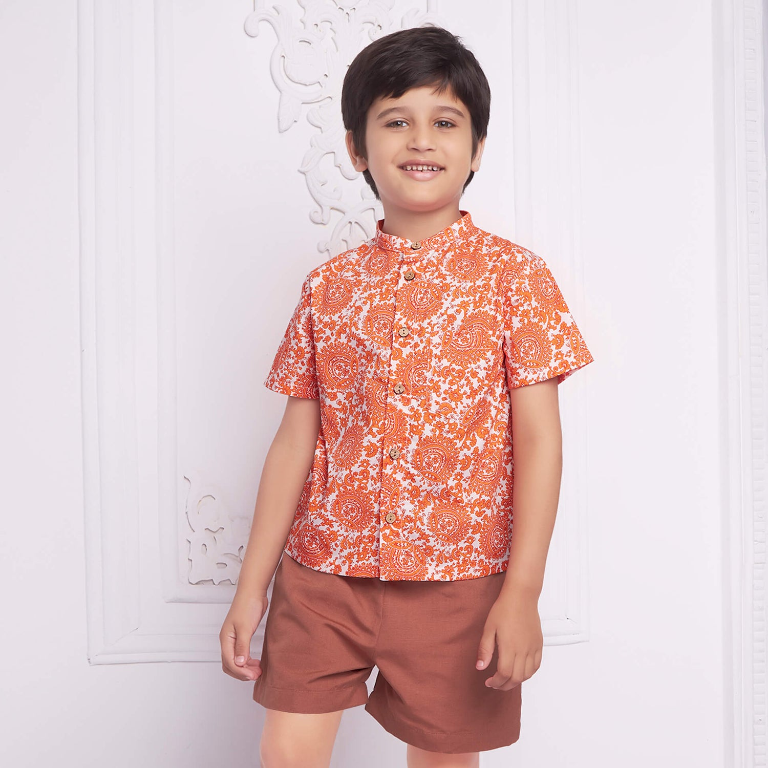 Boy wearing ethnic print shirt and shorts
