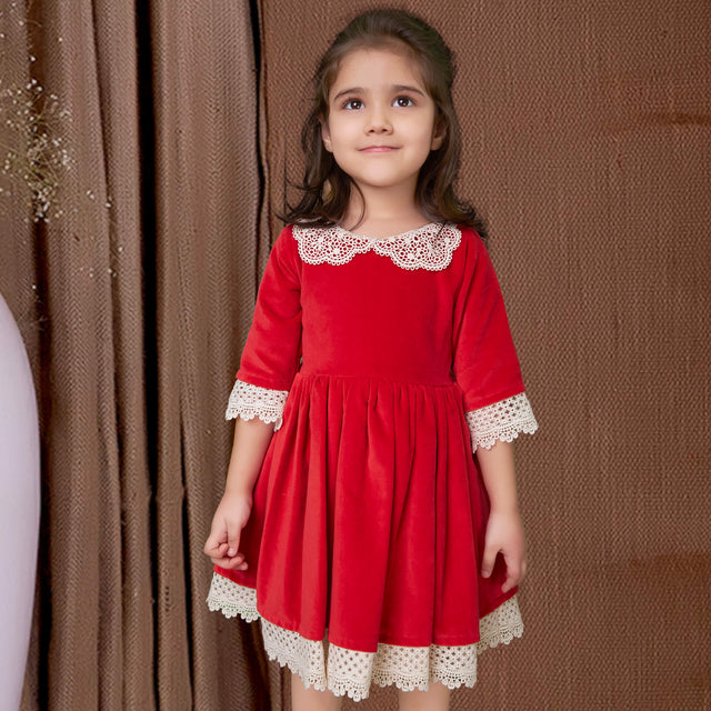 Cute girl in red velvet dress adorned with white lace