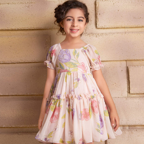 A smiling girl wearing a pink chiffon ruffle dress