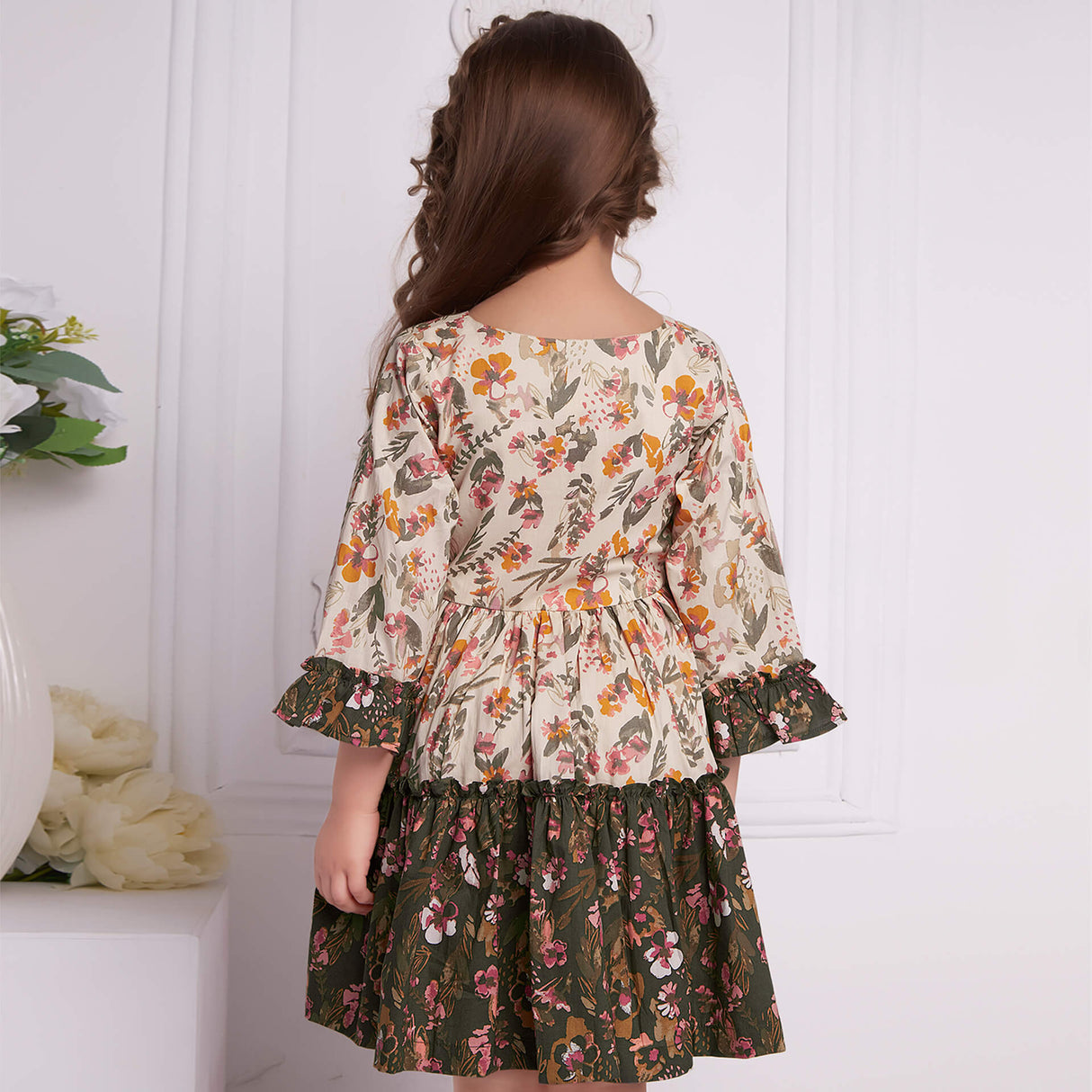 Back view of a girl dressed in a ruffle dress in contrast tones