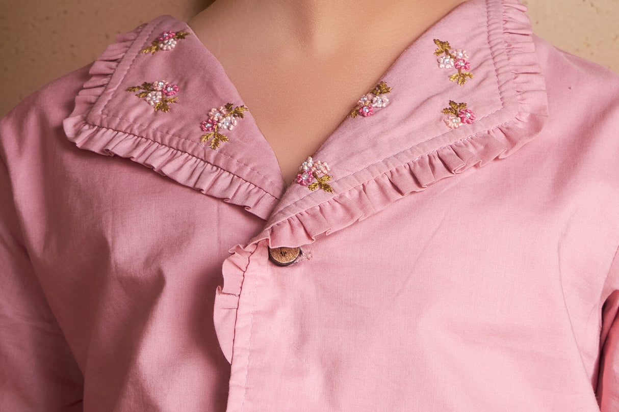 Detailed close up of pink embroidered lapel collared blouse