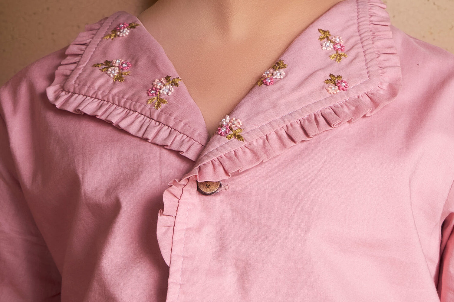 Detailed close up of pink embroidered lapel collared blouse
