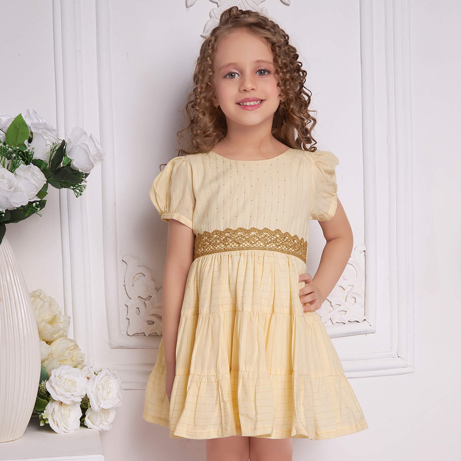 A girl in ivory beads dress with gold metallic lace at the waist