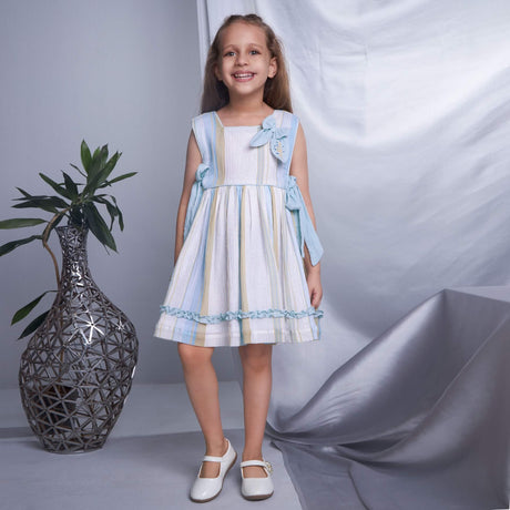 A smiling girl in blue lurex embroidered bow dress, posing straight