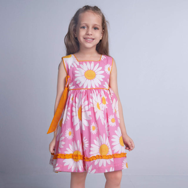 A girl in sleeveless pink floral dress with side ties