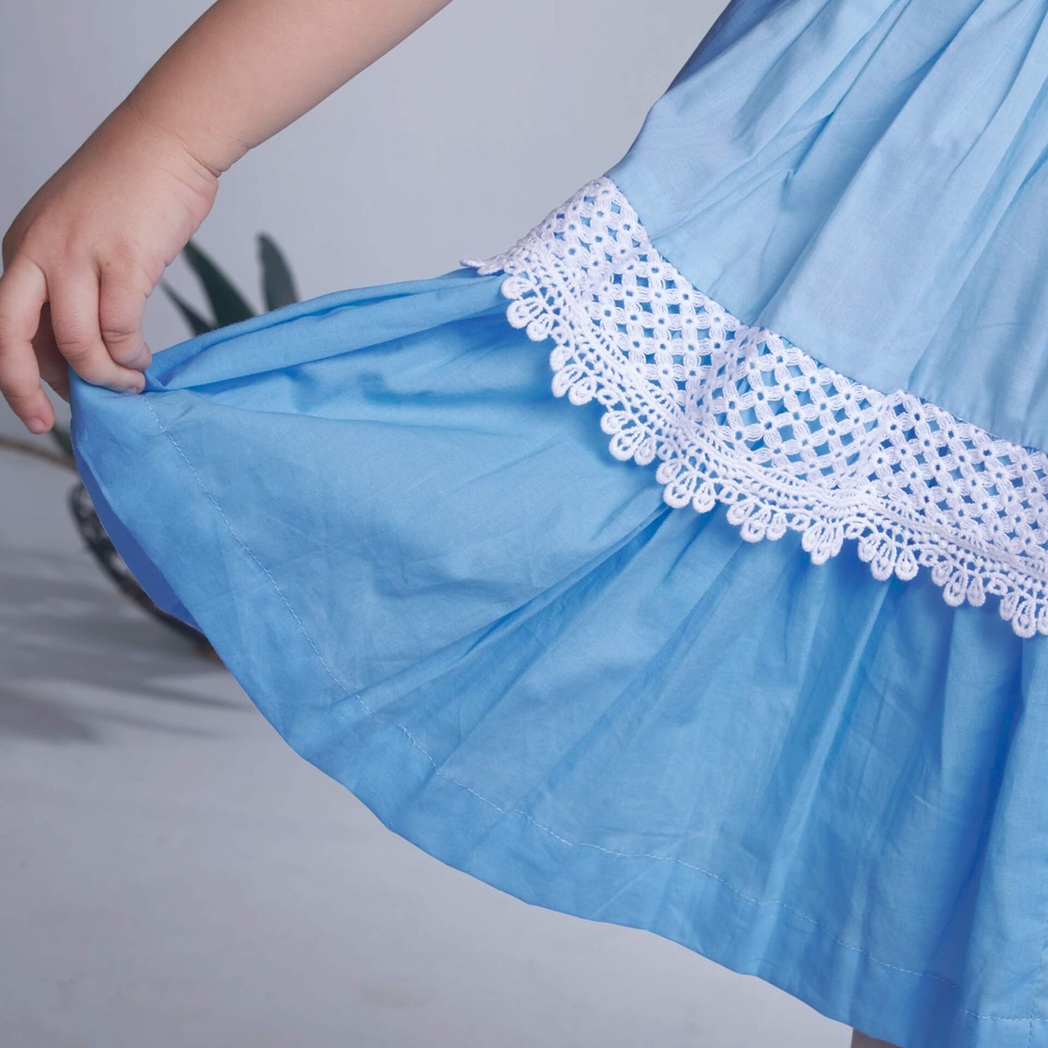 Detailed shot of delicate lace in a blue ombre embroidered dress