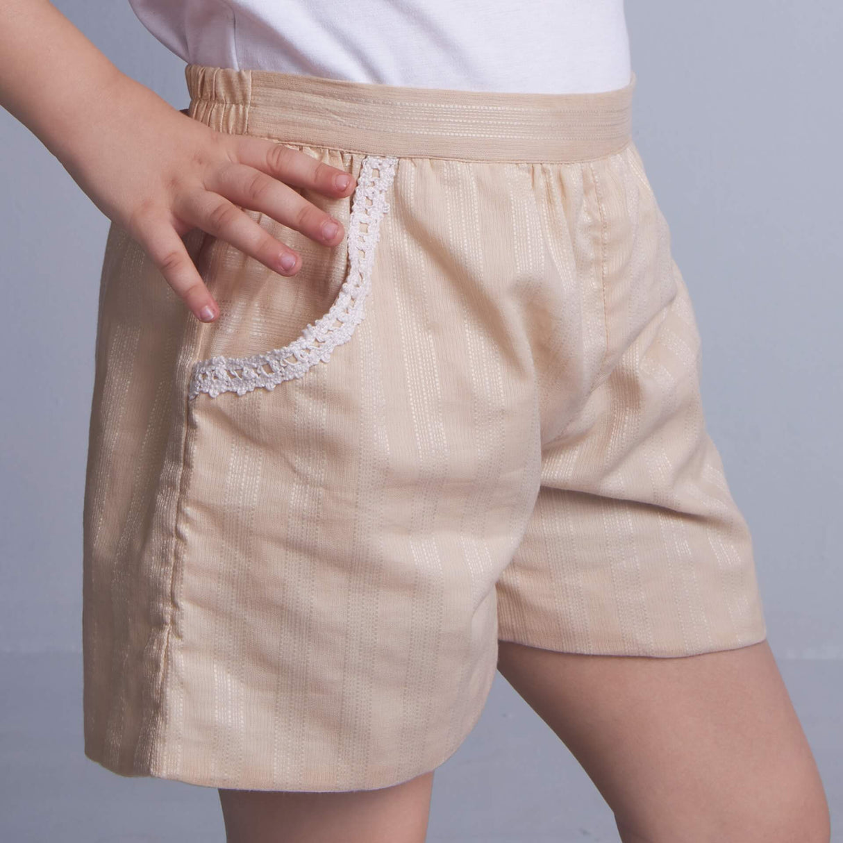 Side view of a tan embroidered shorts with dual side pockets