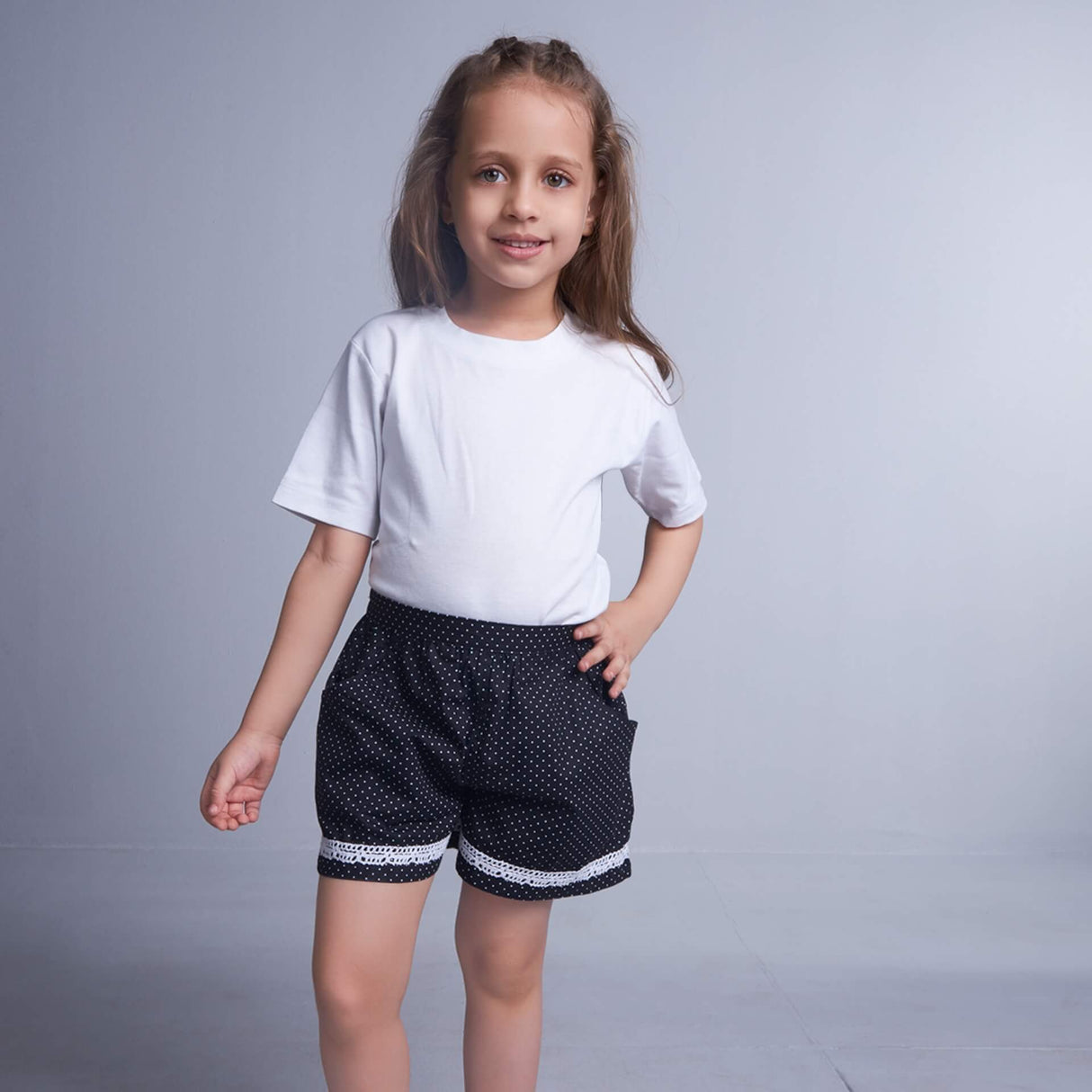 A girl in dot printed black shorts with side pockets and contrast trims