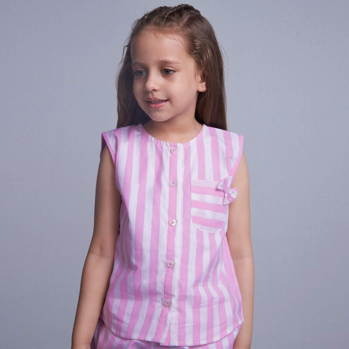 Closeup of a girl wearing pink stripes co-ords set with pocket detail