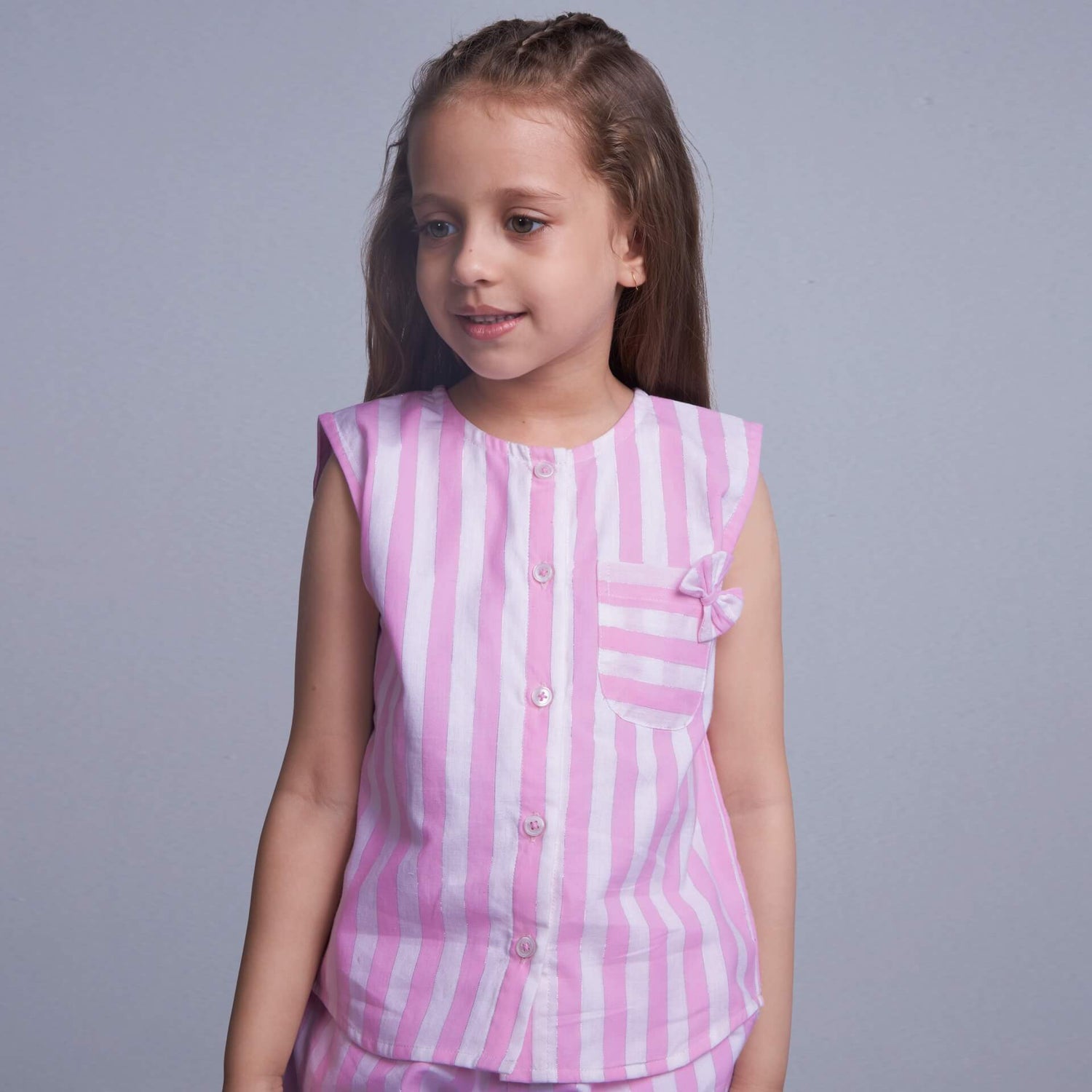 Closeup of a girl wearing pink stripes co-ords set with pocket detail