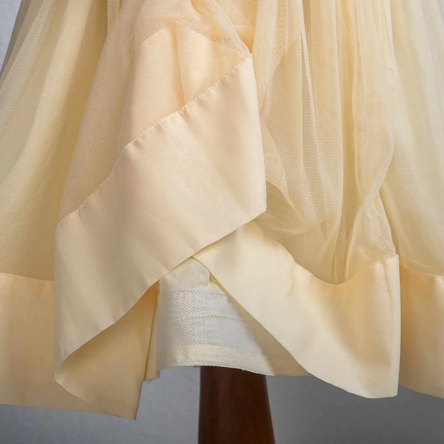 "Close-up of the can-can fabric attached to the yellow tulle skirt of the dress."