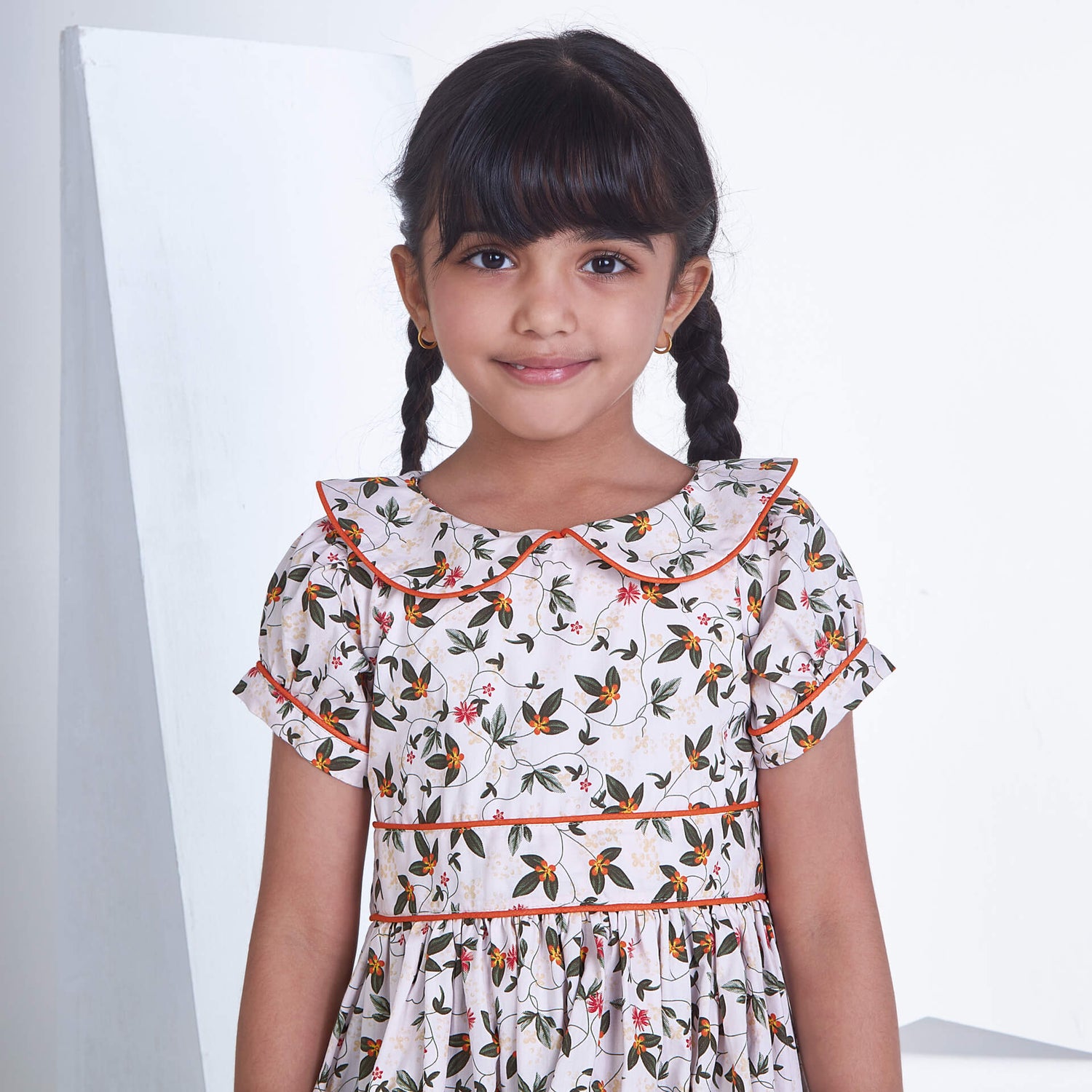 Close up of a girl white floral printed collared dress with adjustable belt at the waist