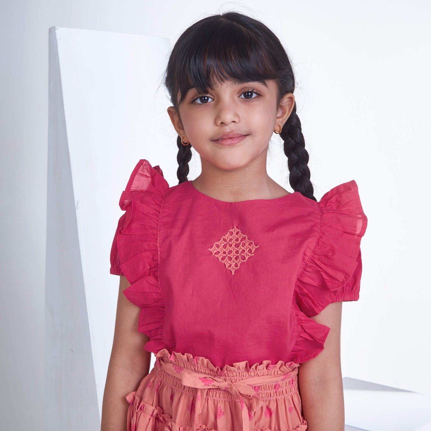 Closeup of a girl in pink embroidered blouse and peach floral printed skirt