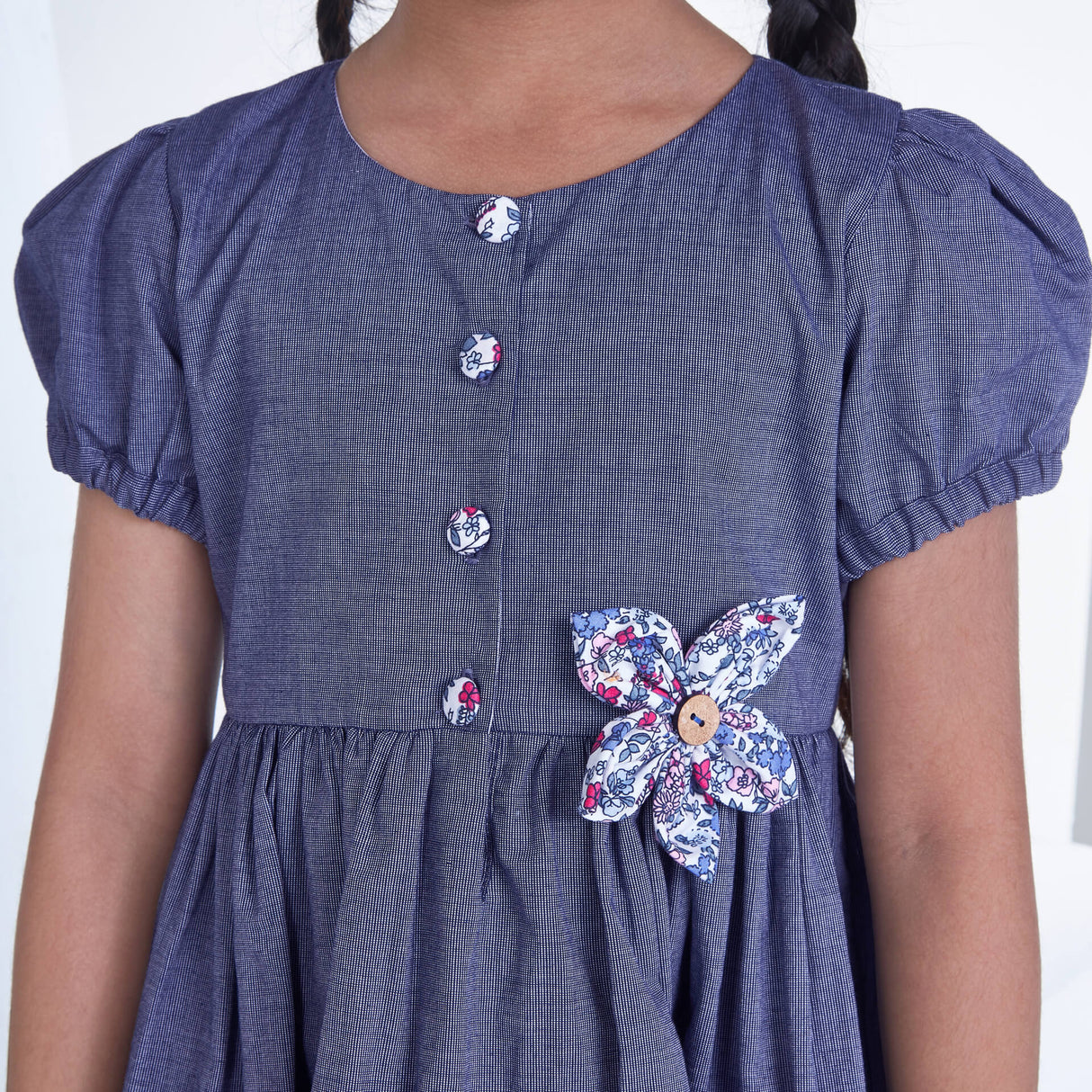 Closeup of a girl wearing navy flower applique dress