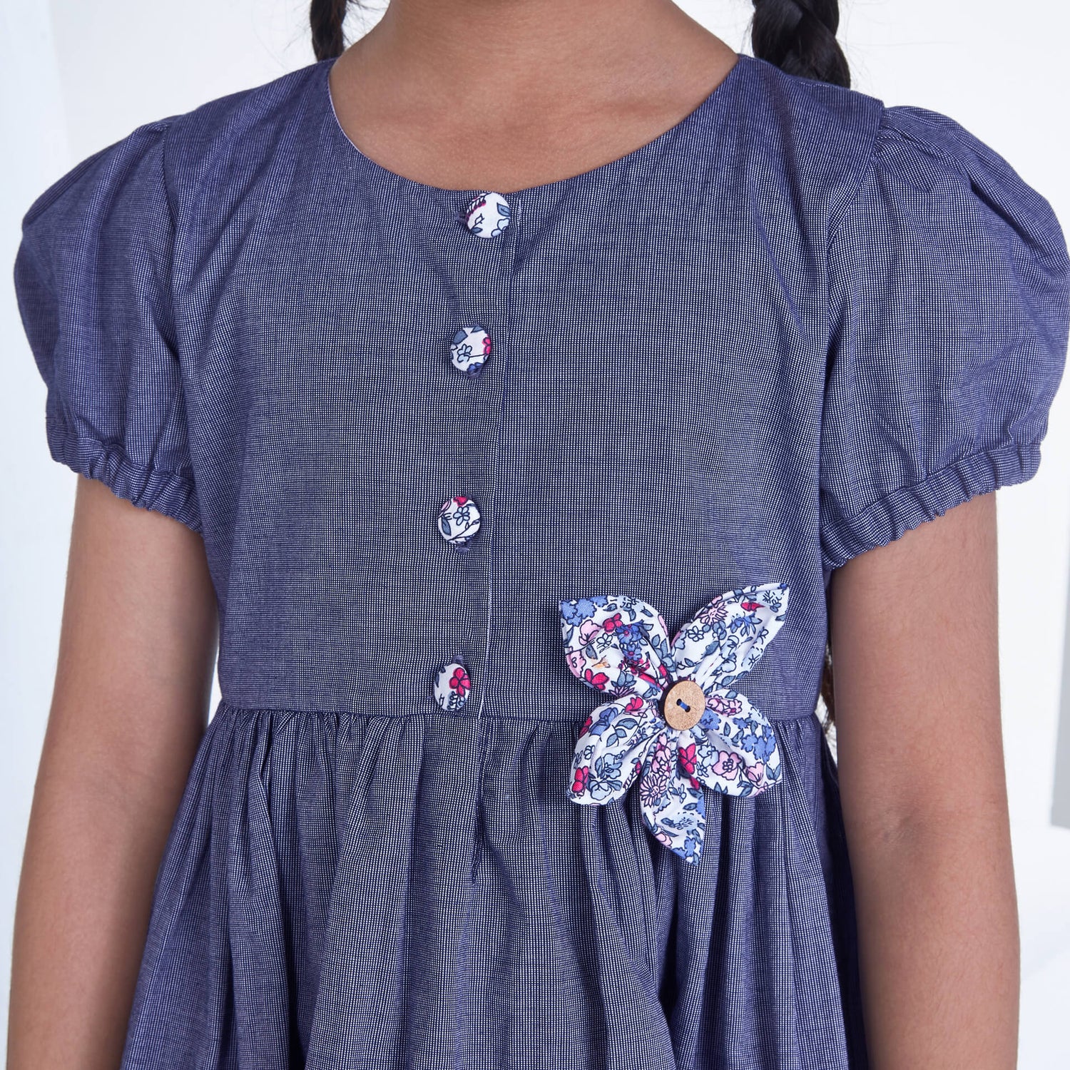 Closeup of a girl wearing navy flower applique dress