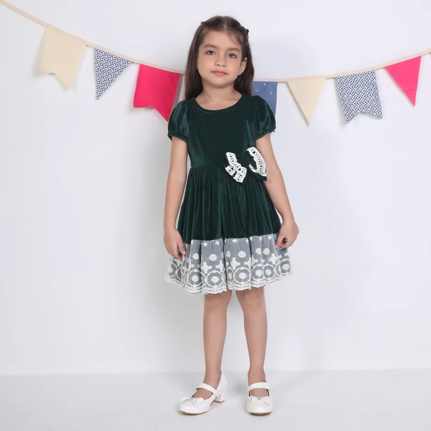 A girl dressed in a green ivory lace velvet puffed sleeves dress.