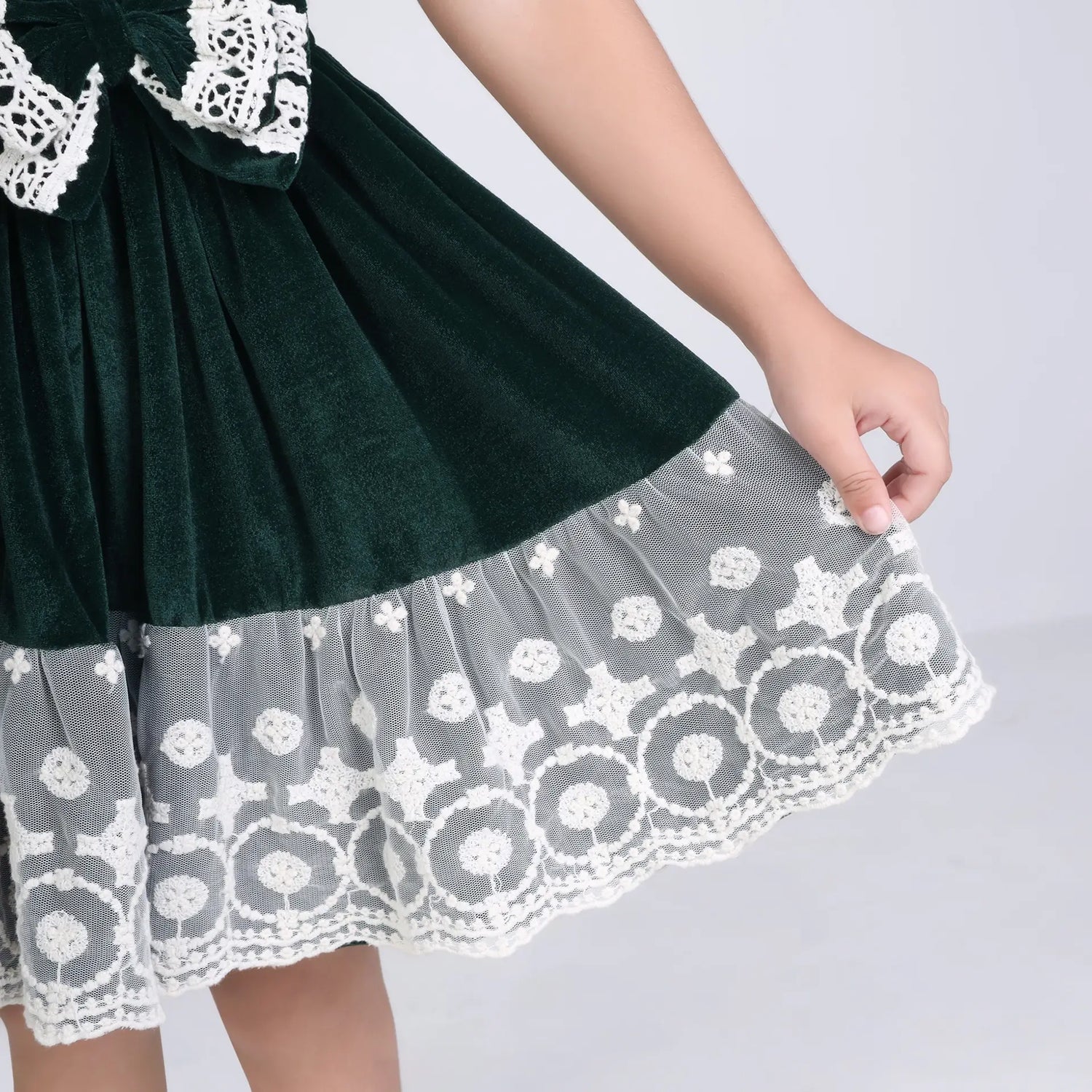 Close-up of the skirt on the green ivory lace velvet puffed sleeves dress.