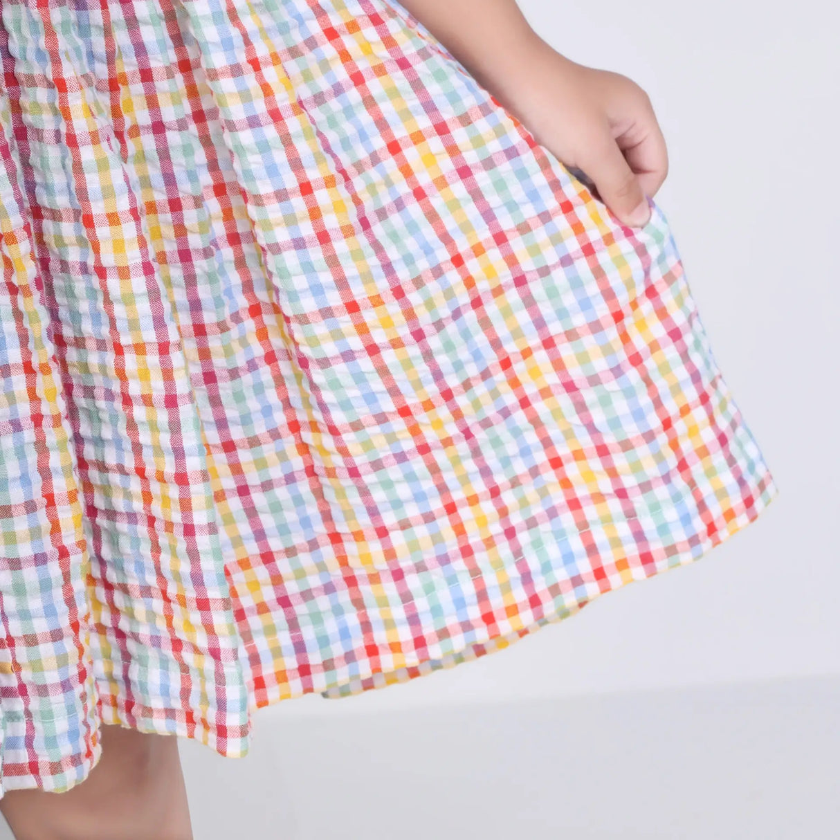 Close-up of the skirt of the multi-color checked embroidered cotton puffed sleeves dress.