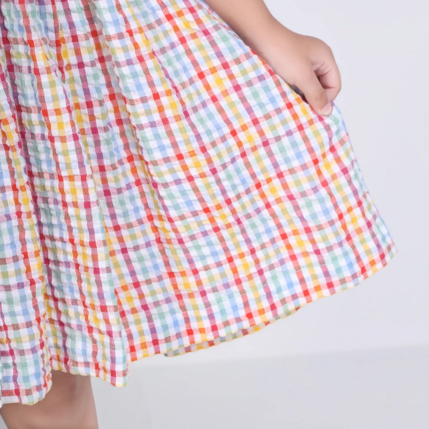 Close-up of the skirt of the multi-color checked embroidered cotton puffed sleeves dress.