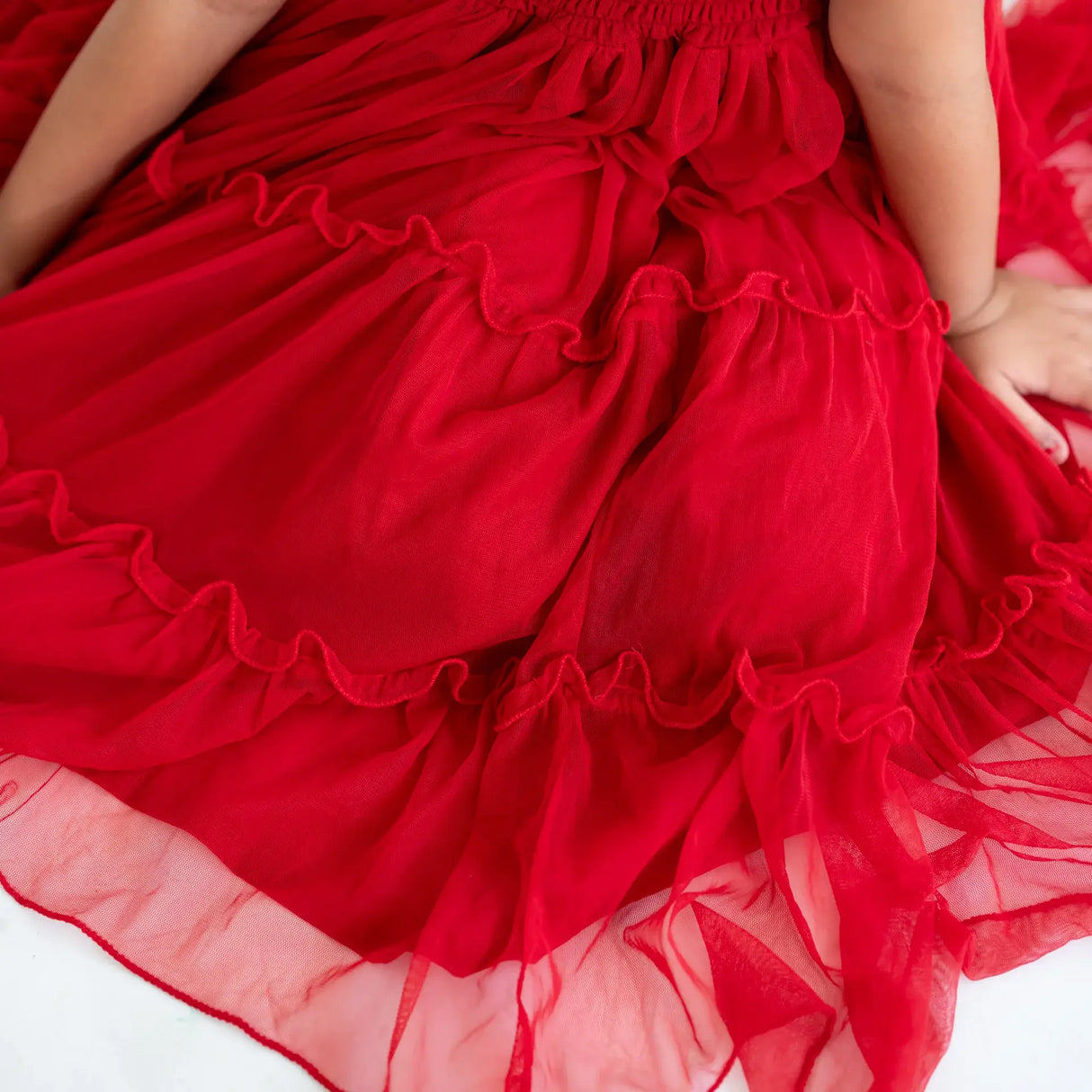 Close-up of the ruffles on a red hand-embroidered crochet nylon tulle sleeveless dress.