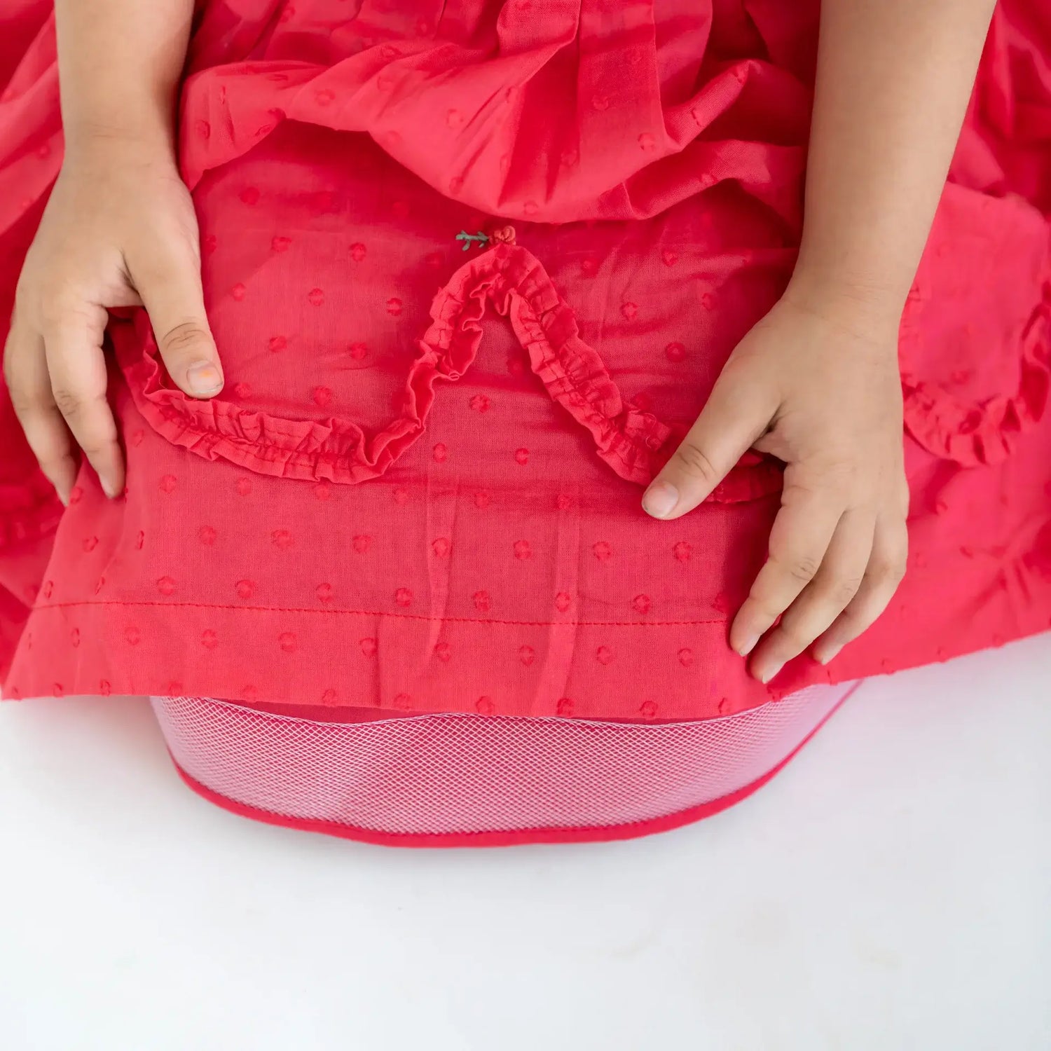 "Close-up of the can-can in the coral swissdot hand smocked and embroidered cotton puffed sleeves dress."