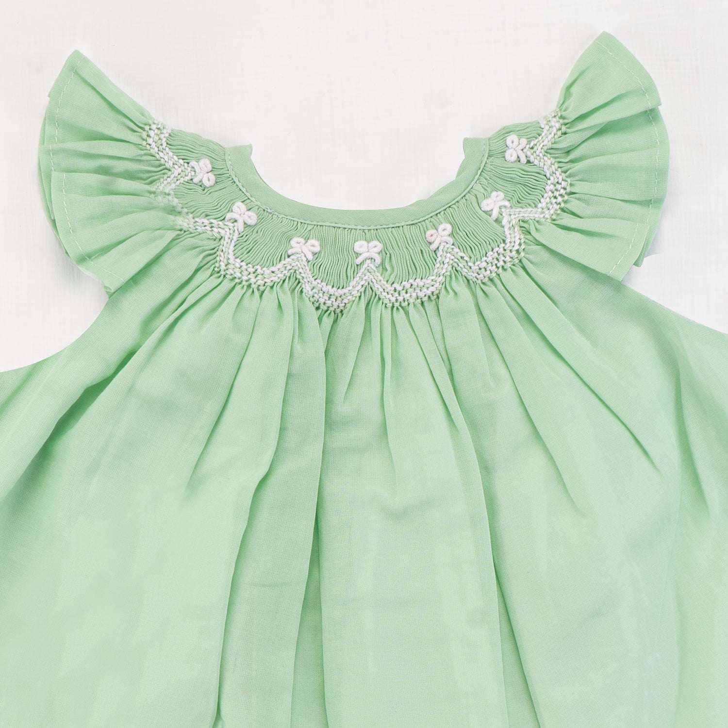Close-up of the smocking detail of green bishop
