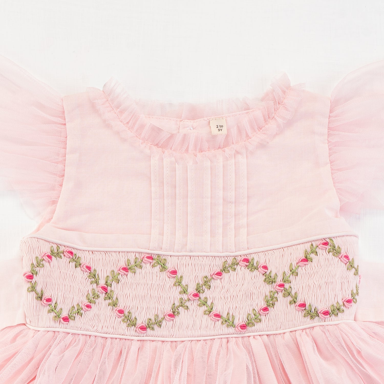 Close-up of the smocking and embroidery details of the pink smocked girls dress