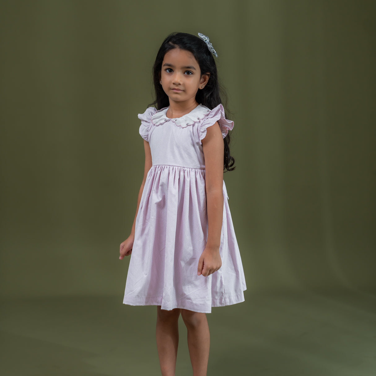 side view of girl dressed in pink dot print dress