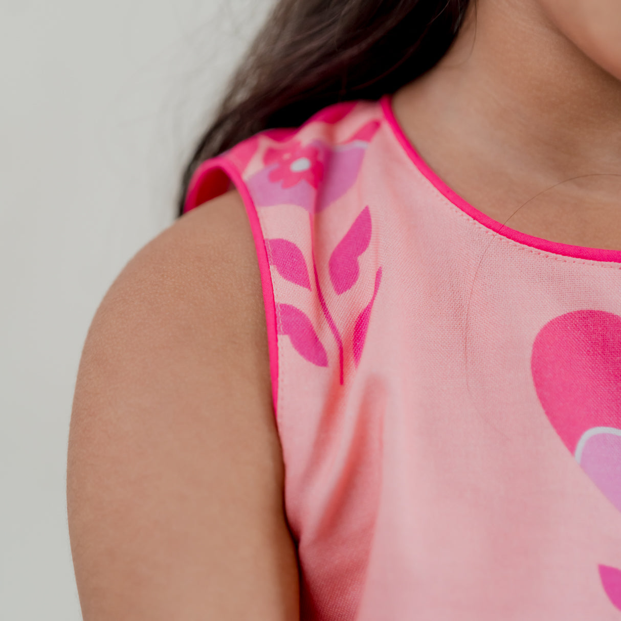 closeup of contrast pink piping on neckline and sleeves of the pink heart print a line dress