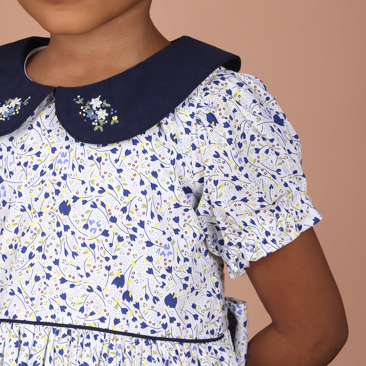 close-up of navy blue peter pan collar with floral hand embroidery