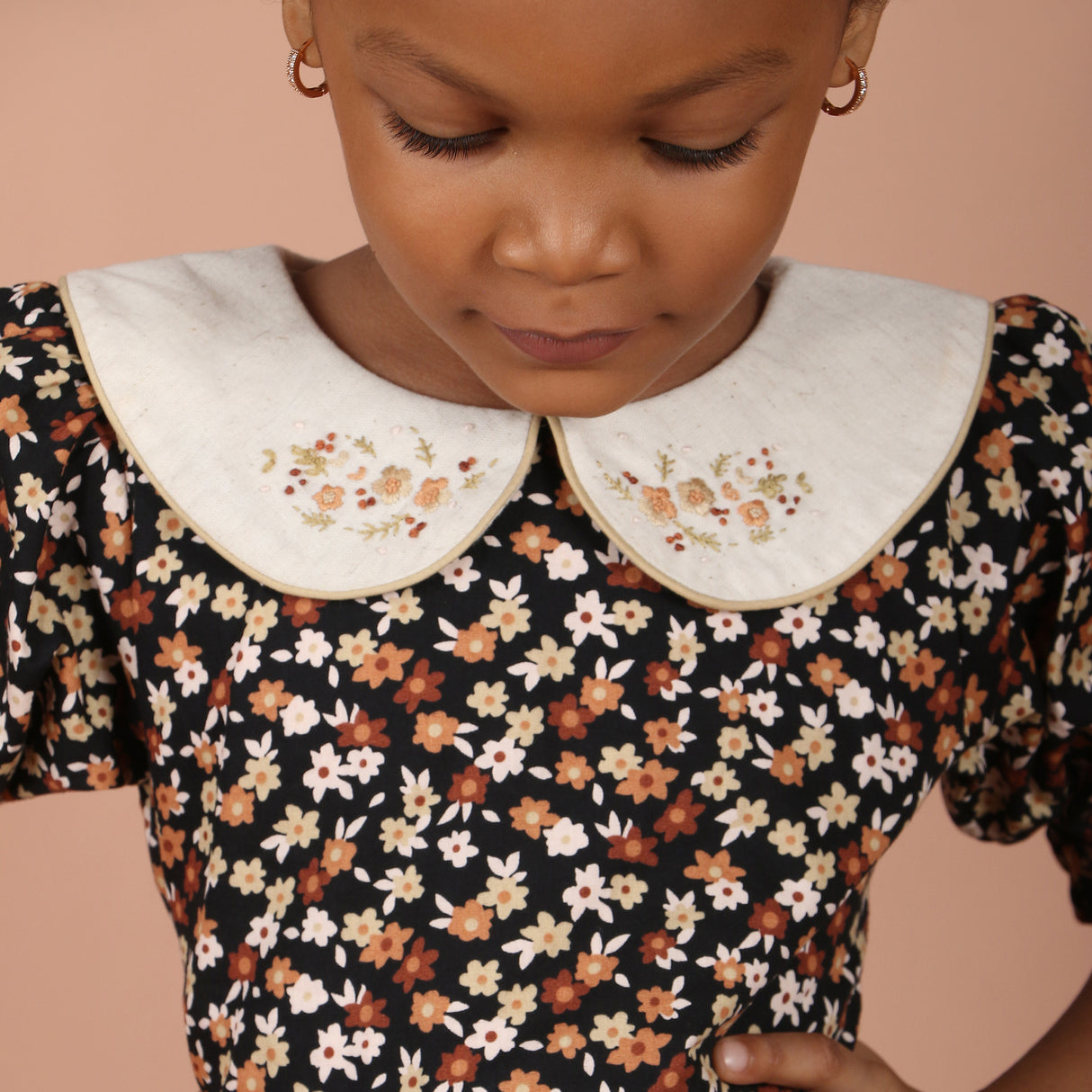 close-up of embroidered peter pan collar on black floral girls dress