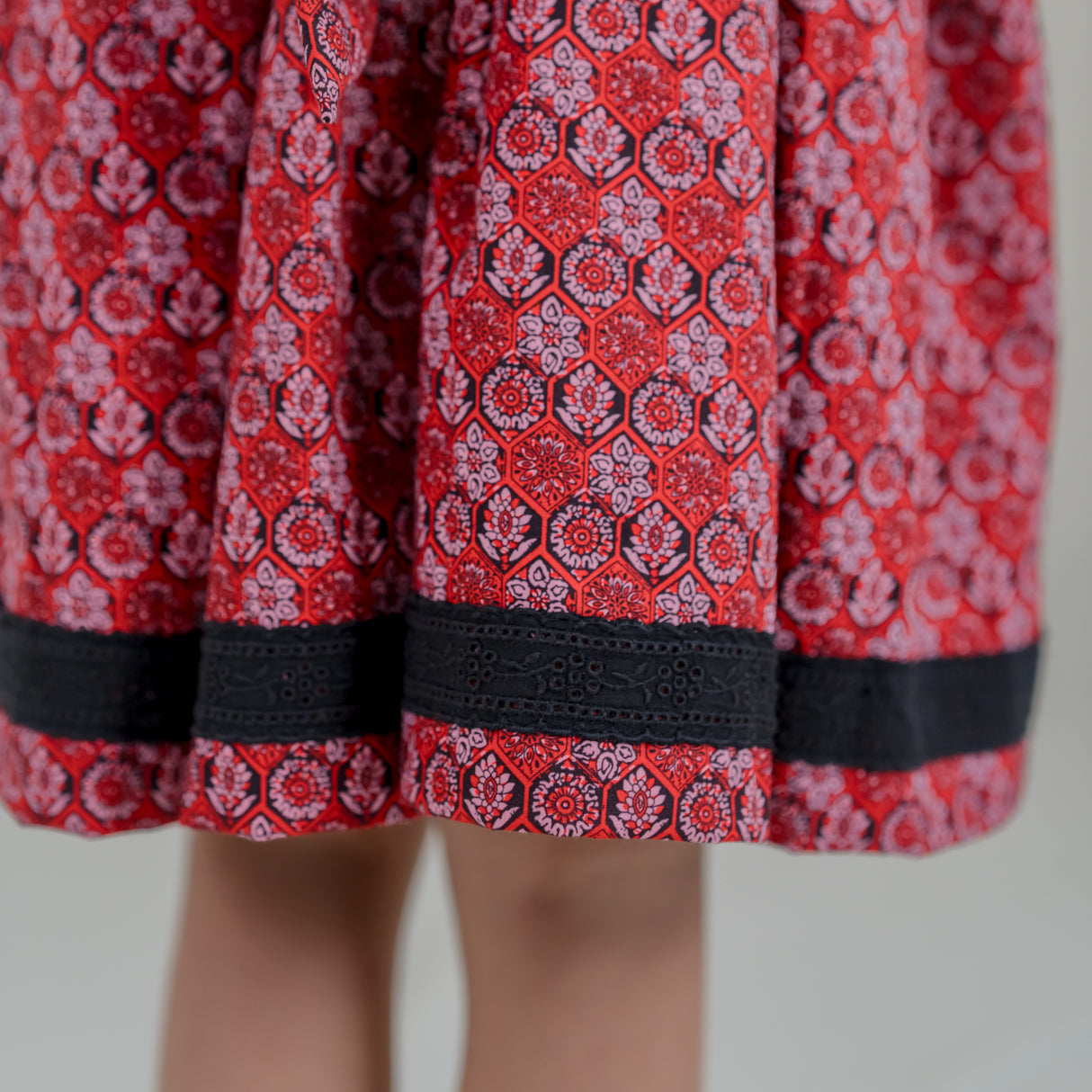 closeup of eyelet lace detail in hemline of black scallop bodice dress