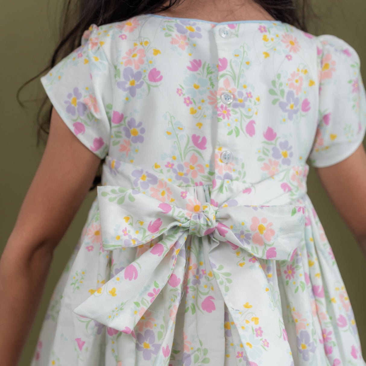 back view showing button closure and waist ties